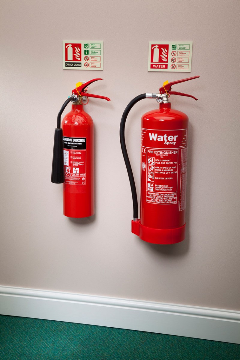Co2 and water fire extinguisher next to each other on wall
